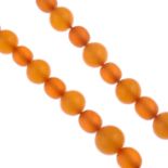An amber bead necklace.Sixty-eight beads, measuring 18 to 9mms.