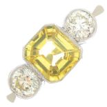 A yellow sapphire and diamond three-stone ring.