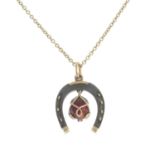 An early 20th century 9ct gold and iron enamel horseshoe pendant,