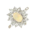 An opal cabochon and diamond cluster ring.Estimated total diamond weight 0.85ct.Stamped 18CT.Ring