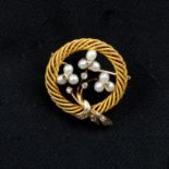 A late 19th century Austrian 18ct gold seed pearl and rose-cut diamond floral wreath brooch.