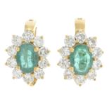 A pair of emerald and diamond cluster earrings.