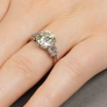 A brilliant-cut diamond single-stone ring, with baguette-cut diamond stepped sides.