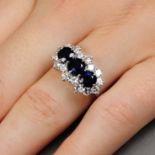 An 18ct gold sapphire three-stone and diamond cluster ring.