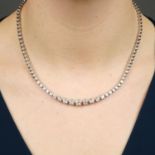 A graduated brilliant-cut diamond collet line necklace.