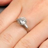 A brilliant-cut diamond single-stone ring, with tapered baguette-cut diamond shoulders.