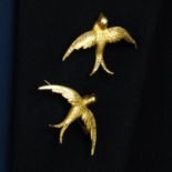 Two early 20th century 18ct gold swallow brooches, with rose-cut diamond accents and ruby eyes.