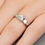 A circular-cut diamond and square-shape Fancy Yellow diamond ring.With reports F1P12379 and