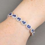 An oval-shape sapphire and brilliant-cut diamond cluster bracelet.