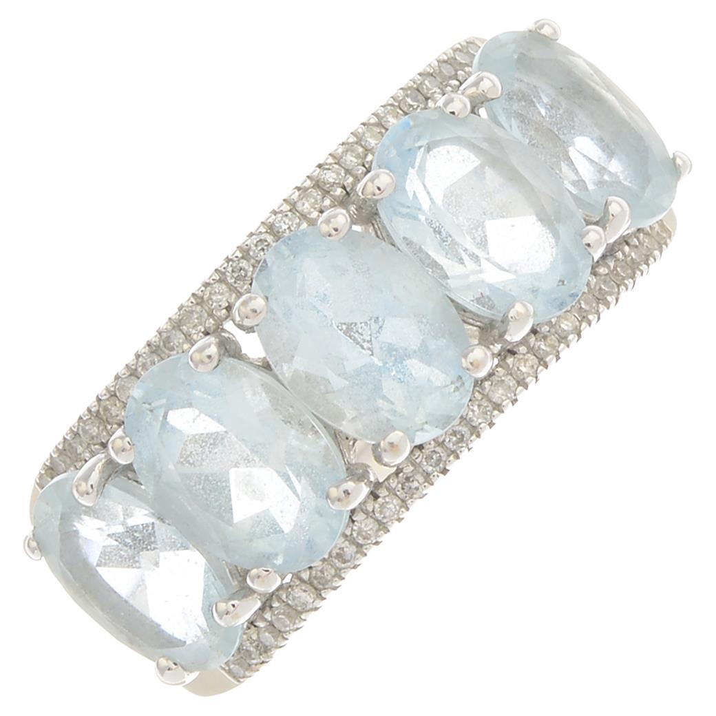 An aquamarine and diamond dress ring.Approximate dimensions of central aquamarine 7 by 5 by