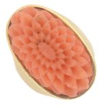 A carved coral single-stone ring.