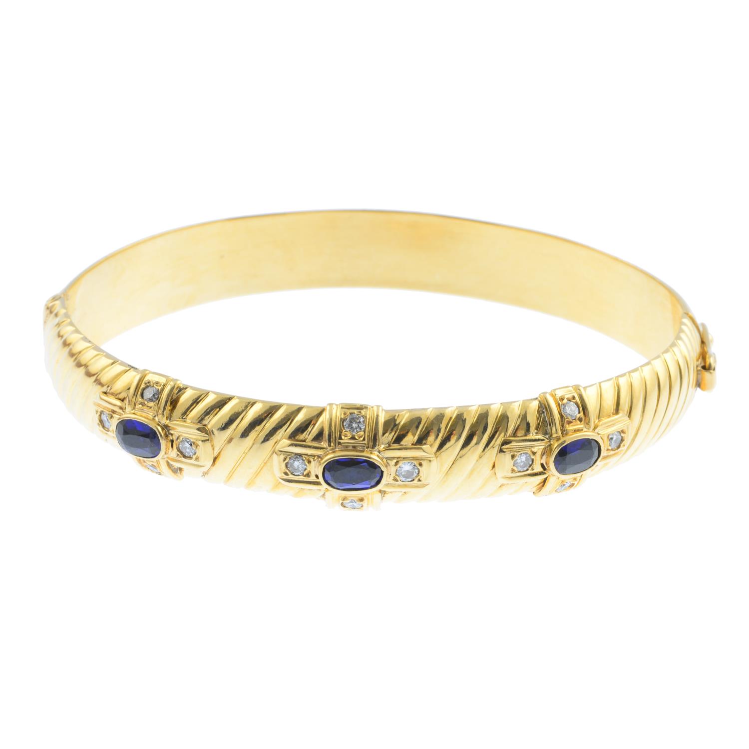 A sapphire and diamond bangle.Estimated total diamond weight 0.35ct.