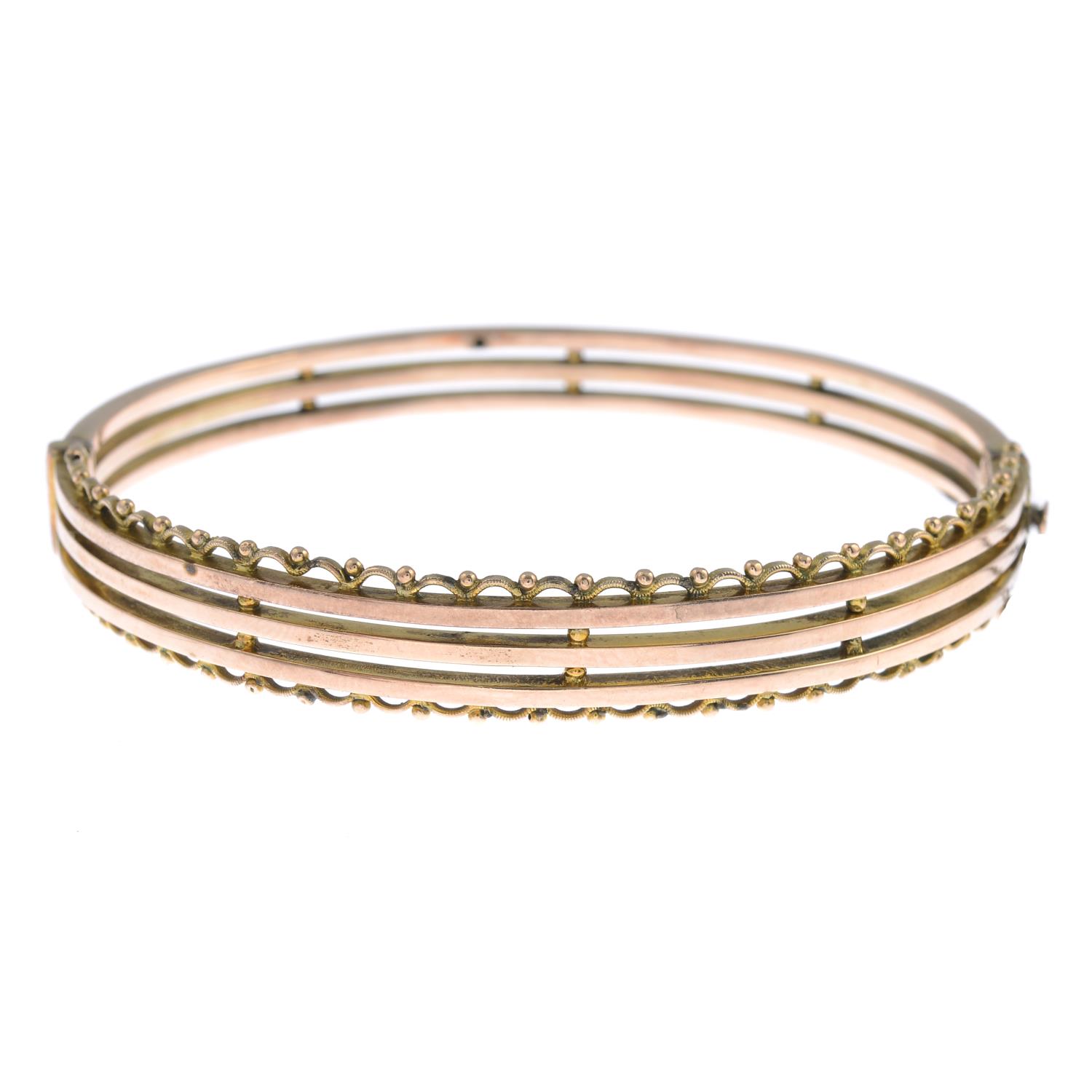 A hinged bangle with scalloped edging.Stamped 9ct.