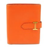 HERMÈS - a small orange leather Bearn wallet.