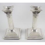 A pair of late Victorian silver mounted candlesticks,