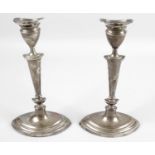 A pair of Edwardian silver candlesticks,