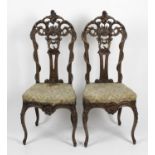 A pair of decorative 19th century carved and stained wooden framed chairs,