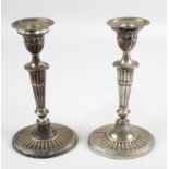 A pair of Edwardian silver mounted candlesticks,