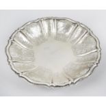 A Scandinavian dish, the circular lobed form chased with floral scrolls to the raised edge.