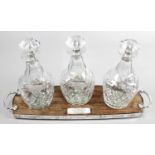 A set of three mid-twentieth century silver mounted glass decanters,