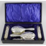 A cased Edwardian silver mounted five piece dressing table set,