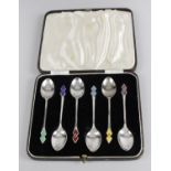 A cased set of six silver coffee spoons with harlequin diamond enamel terminals,