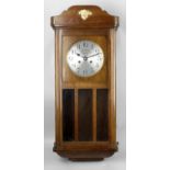 A 1930's stained wooden cased wall clock,