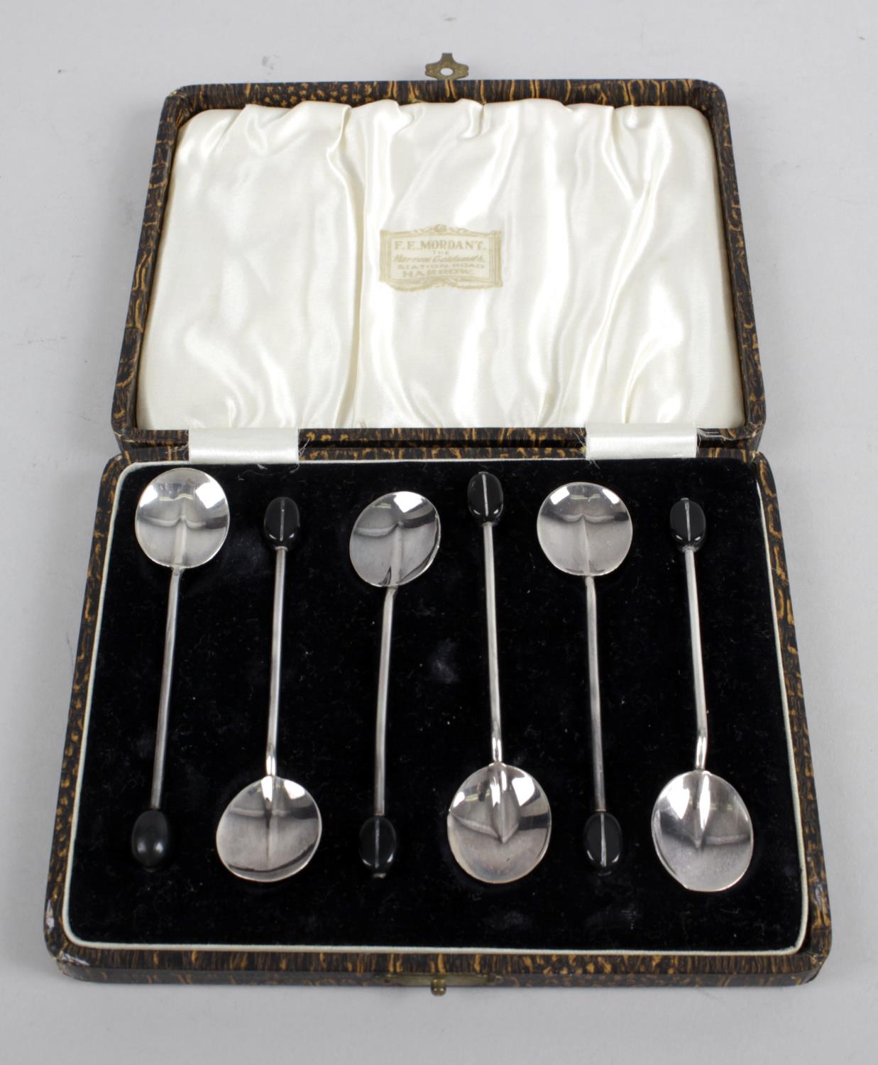 A cased set of six 1920's silver coffee spoons with coffee bean terminals,