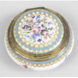 A 19th century French circular enamelled pill box with hinged cover,