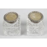 A pair of Edwardian cut glass silver topped inkwells,