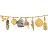 An early 20th century gold and gold plated charm bracelet, suspending ten charms.Length 17cms.