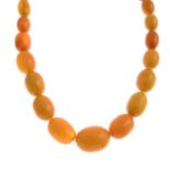 An amber bead necklace.Comprising sixty-seven graduated beads,