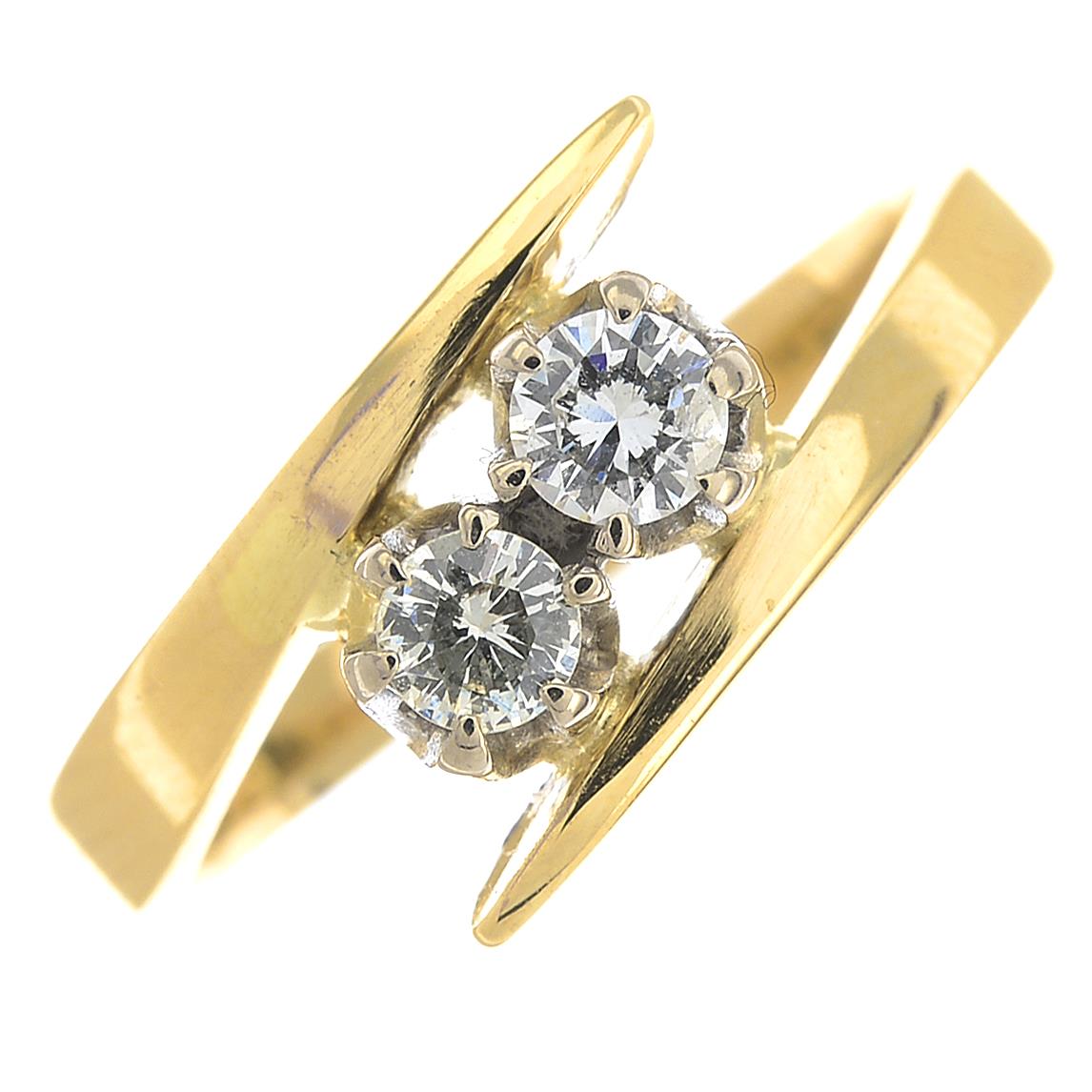 An 18ct gold diamond two-stone ring.Estimated total diamond weight 0.30ct,