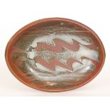 A David Frith studio pottery stoneware shallow oval dish with a dark brown glaze,