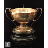 A hallmarked silver tri handled pedestal trophy of plain from, all to a turned wooden base,