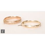 An early 20th Century 9ct rose gold hinged bangle with part foliate engraved decoration, weight 13g,