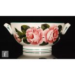 A Wemyss Ware twin handled bowl decorated with hand painted cabbage roses,
