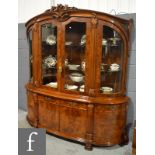 A 20th Century Continental bow front display cabinet enclosed by a pair of glazed doors below a