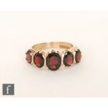 A modern 9ct hallmarked graduated five stone garnet ring, claw set stones to chamfered shoulders,