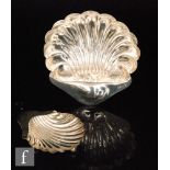 An early 20th Century shell shaped butter dish raised on three ball feet, length 15cm,