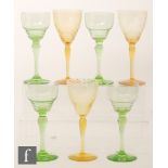 A set of four uranium green wine glasses with pan topped and stepped bowls and inverted baluster