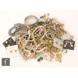 A parcel lot of assorted costume jewellery to include brooches, bangles, earrings, rings, beads etc.