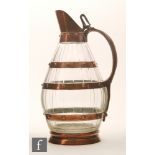 A 19th Century glass jug of coopered design, the ovoid form with mitre cuts, three copper bands,