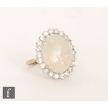 A 9ct hallmarked opal and diamond cluster ring, central oval claw set opal, length 18mm,