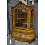 A reproduction walnut veneered bookcase or cabinet on chest,