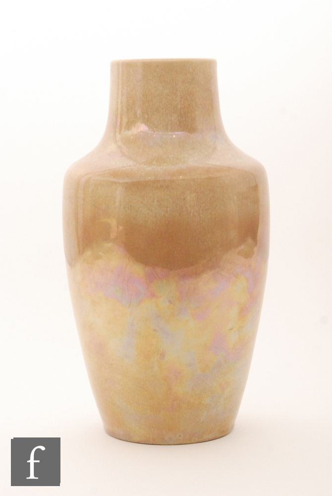 A large Ruskin Pottery vase decorated in an all over pale orange lustre with a sweeping curtain to