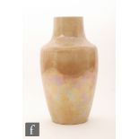 A large Ruskin Pottery vase decorated in an all over pale orange lustre with a sweeping curtain to