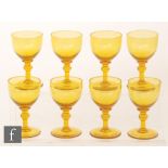 A set of eight late 19th Century golden amber wine glasses with round funnel bowls,