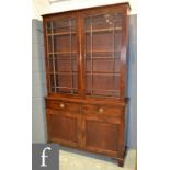 A George III mahogany bookcase cabinet enclosed by a pair of bar glazed doors on a cupboard base
