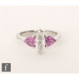 A platinum set diamond and pink sapphire three stone ring, central marquise cut claw set diamond,